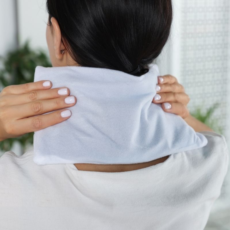 Woman using Hot Towel for Pain Relief